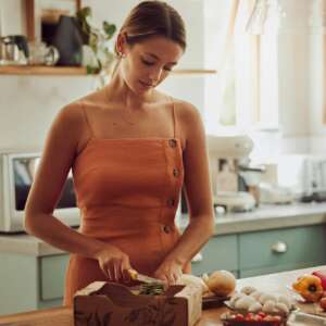 Cooking, healthy and cutting vegetables while a woman prepares an organic, nutritional and vegetari