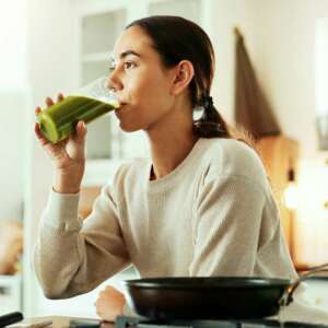 Nutritionist, smoothie and drink in kitchen for health, nutrition and breakfast with morning cookin